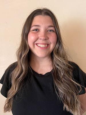 White woman with long brown hair wearing a black shirt